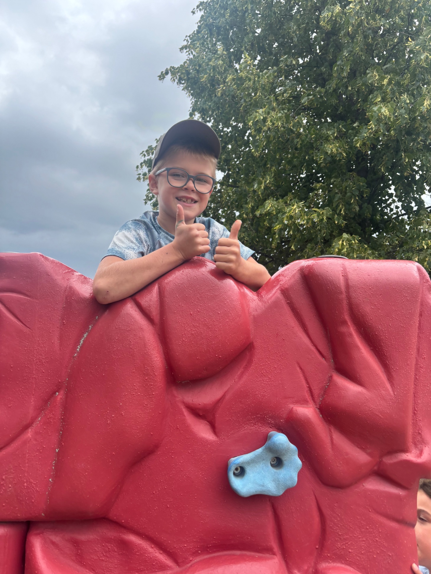 Student with thumbs up playing outside